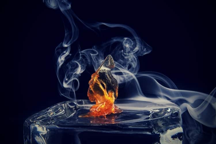 Cannabis oil concentrate aka shatter with smoke isolated over dark background Cannabis oil concentrate aka shatter with smoke isolated over dark background