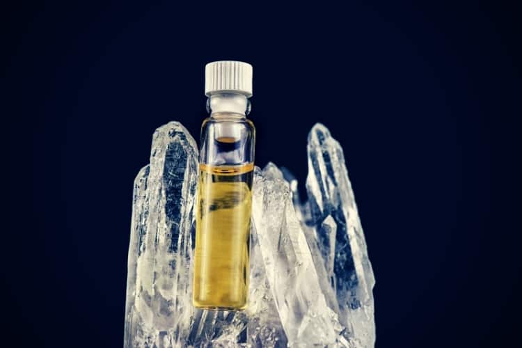 Detail of cannabis oil container and quartz crystal isolated on black Detail of cannabis oil container and quartz crystal isolated on black