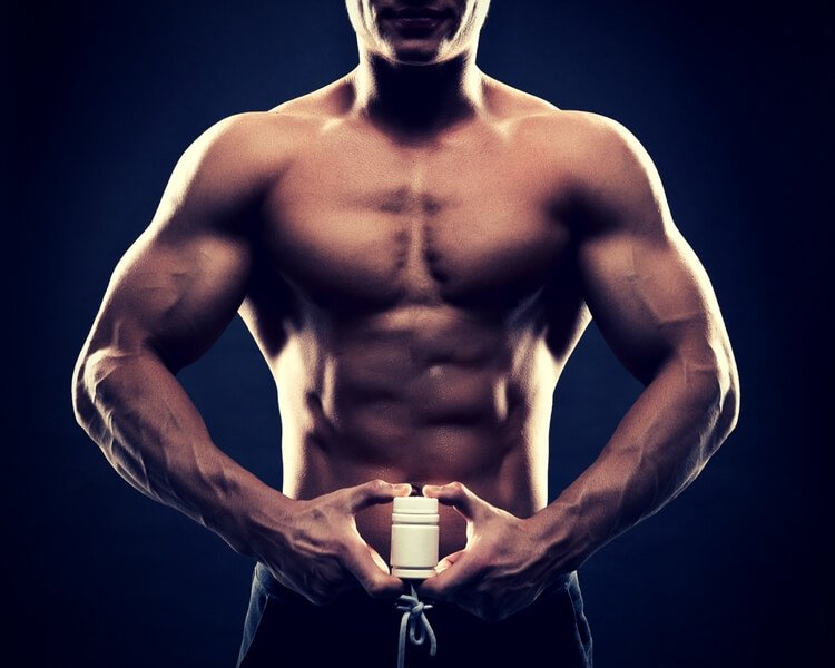bodybuilder holding a white jar of pills
