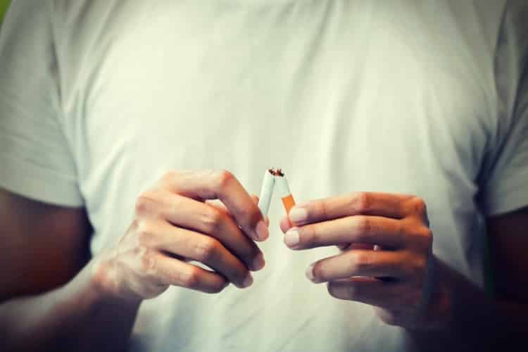 The man use hands breaking down cigarettes The man use hands breaking down cigarettes