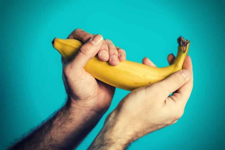 two hands of a man holding a banana two hands of a man holding a banana